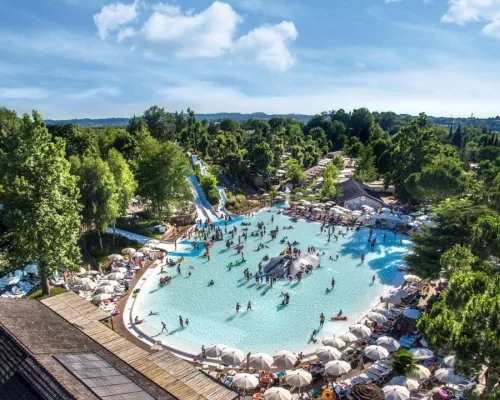 Overzicht lagune zwembad met glijheuvels en glijbanen op Roan camping hu Altomincio village.