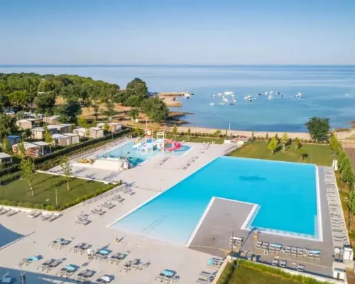 Zwembad met kinderbad en glijbaantjes en baai op Roan camping Park Umag.