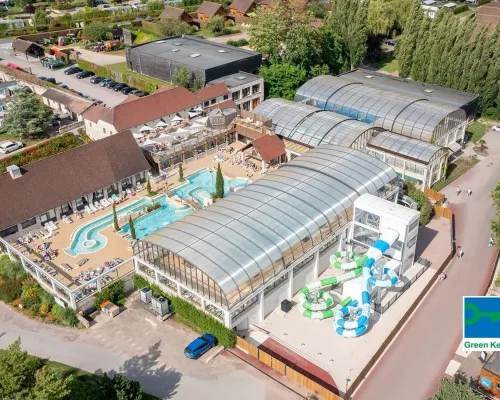 Overzicht van het binnen en buitenzwembad op Roan camping La Croix du Vieux Pont.